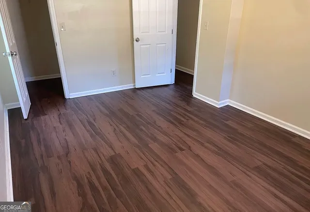 an empty room with wooden floor and closet