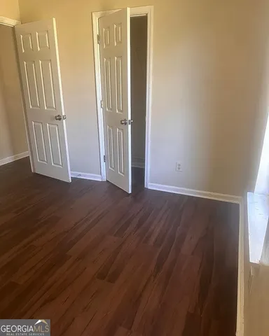 an empty room with wooden floor and door
