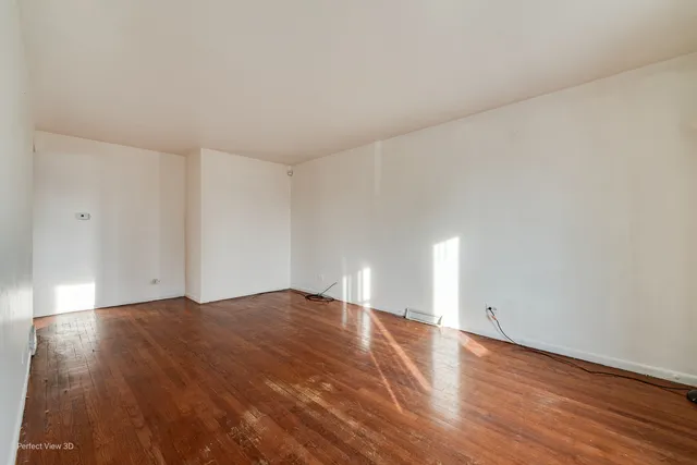 a view of an empty room and wooden floor