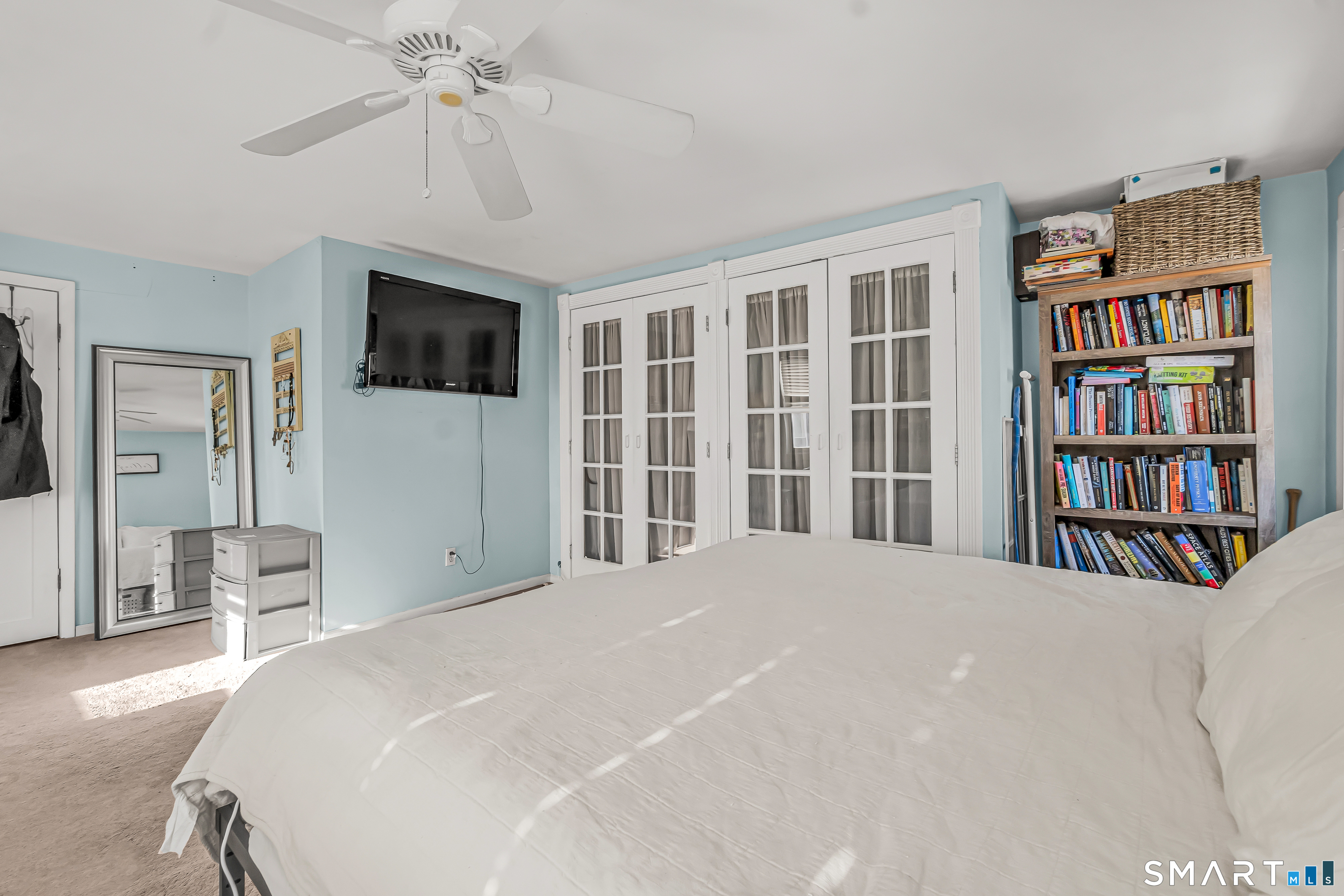 106 Hawley Avenue Milford, CT 06460 - Photo 4 of 39 a bedroom with a large bed a flat screen tv and a book shelf