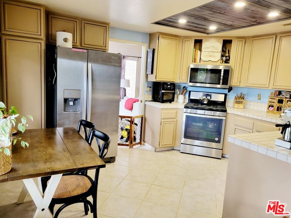 1744 Crystal Ridge Way Vista, CA 92081 - Photo 4 of 20 a kitchen with stainless steel appliances granite countertop a refrigerator a stove top oven a sink dishwasher and white cabinets with wooden floor