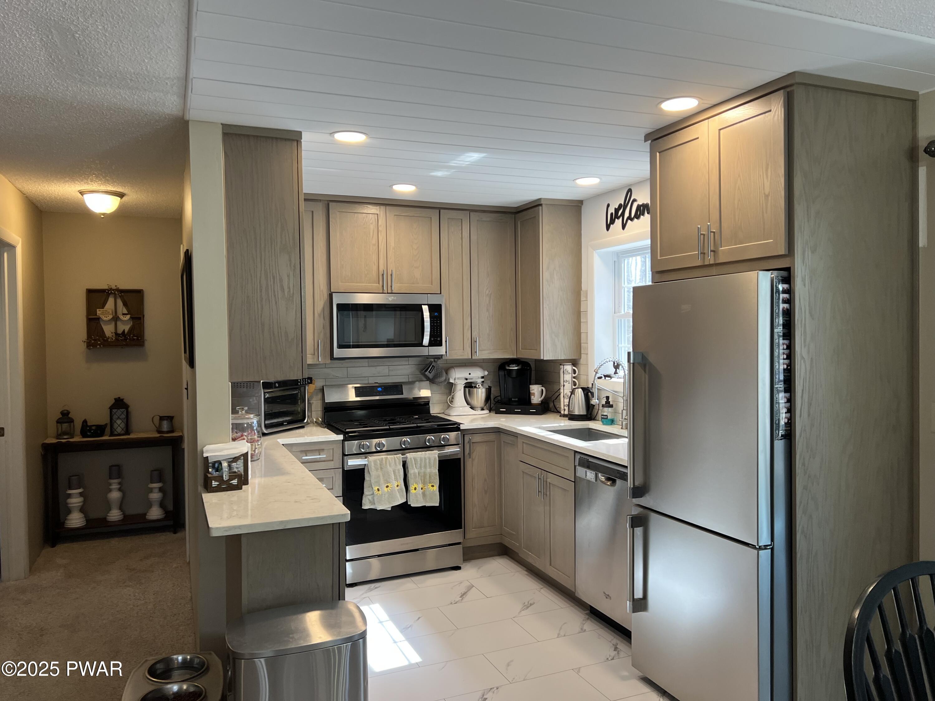 119 Rodeo Drive Hawley, PA 18428 - Photo 25 of 34 a kitchen with stainless steel appliances granite countertop a refrigerator a stove and a sink