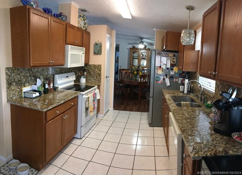 16241 Southwest Five Wood Way Indiantown, FL 34956 - Photo 8 of 10 a kitchen with stainless steel appliances granite countertop a sink and cabinets