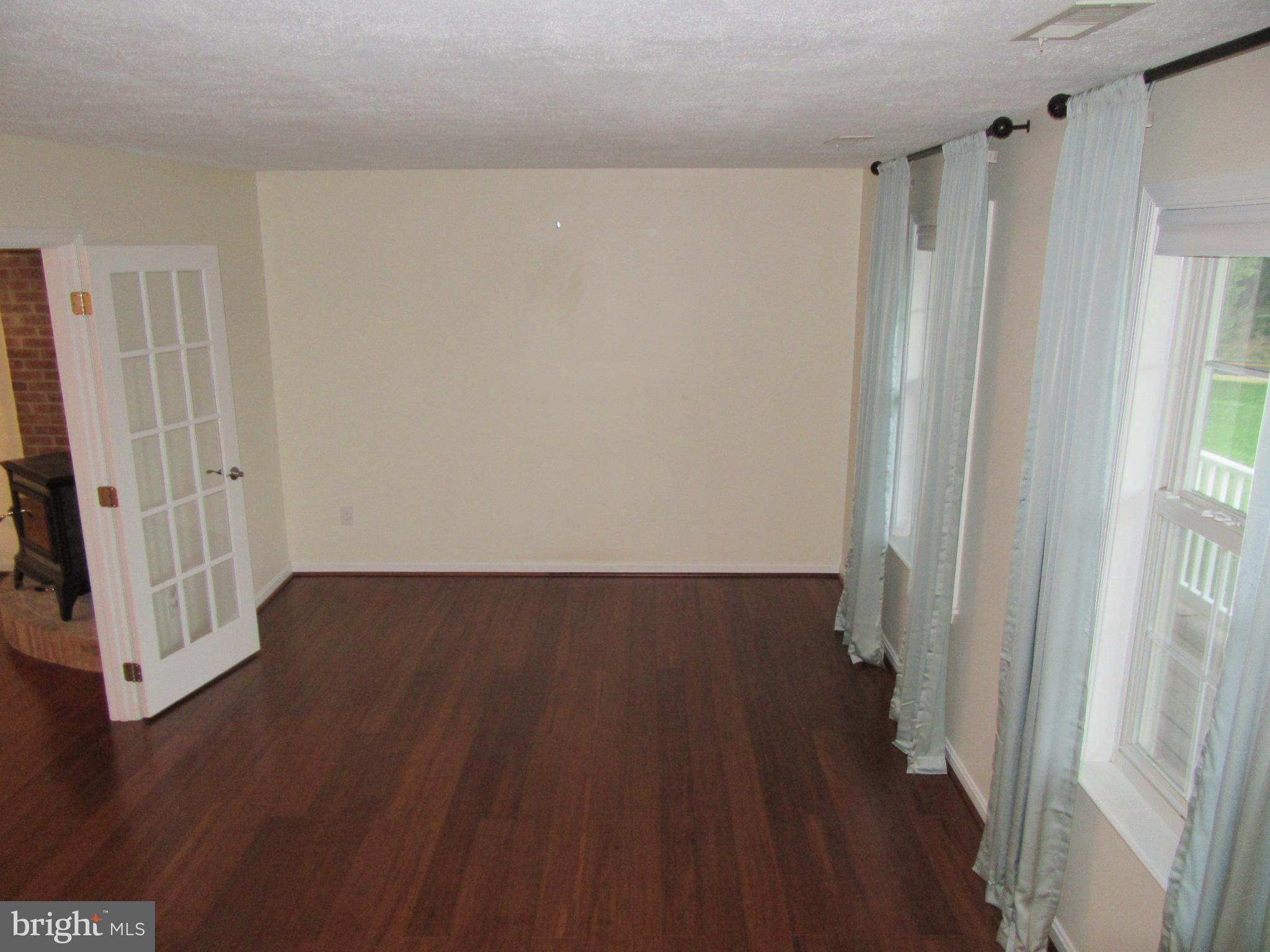 11905 Mill Bridge Road Lusby, MD 20657 - Photo 15 of 59 a view of a room with wooden floor and white walls