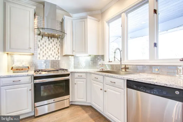 a kitchen with granite countertop white cabinets a sink and white appliances