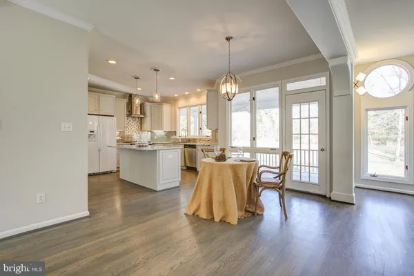 a view of a dining room and livingroom with furniture wooden floor a rug and a chandelier