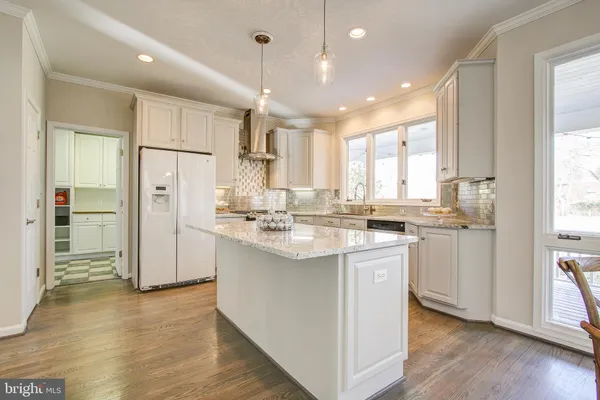 a kitchen with stainless steel appliances granite countertop a sink a refrigerator and a stove with wooden floor