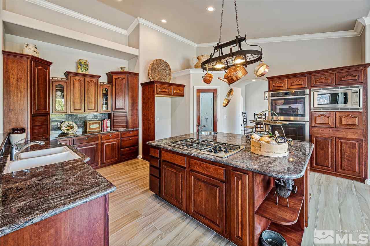 1585 Star Way Reno, NV 89511 - Photo 8 of 25 a kitchen with stainless steel appliances granite countertop a stove a refrigerator and a wooden cabinets