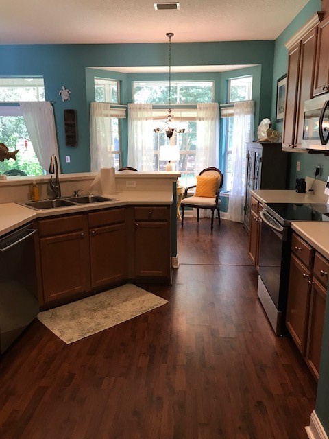 97167 Castle Ridge Drive Yulee, FL 32097 - Photo 2 of 8 a kitchen with stainless steel appliances granite countertop a stove top oven and a view of living room