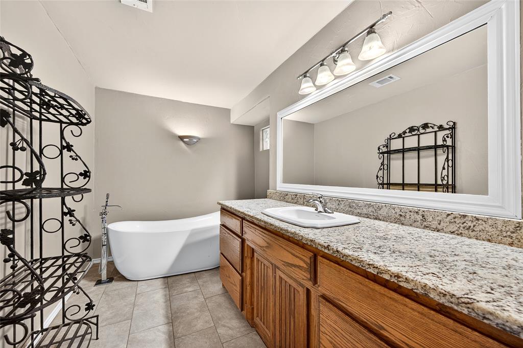 1610 Idlewood Drive Sherman, TX 75092 - Photo 22 of 31 a bathroom with a granite countertop sink and a mirror