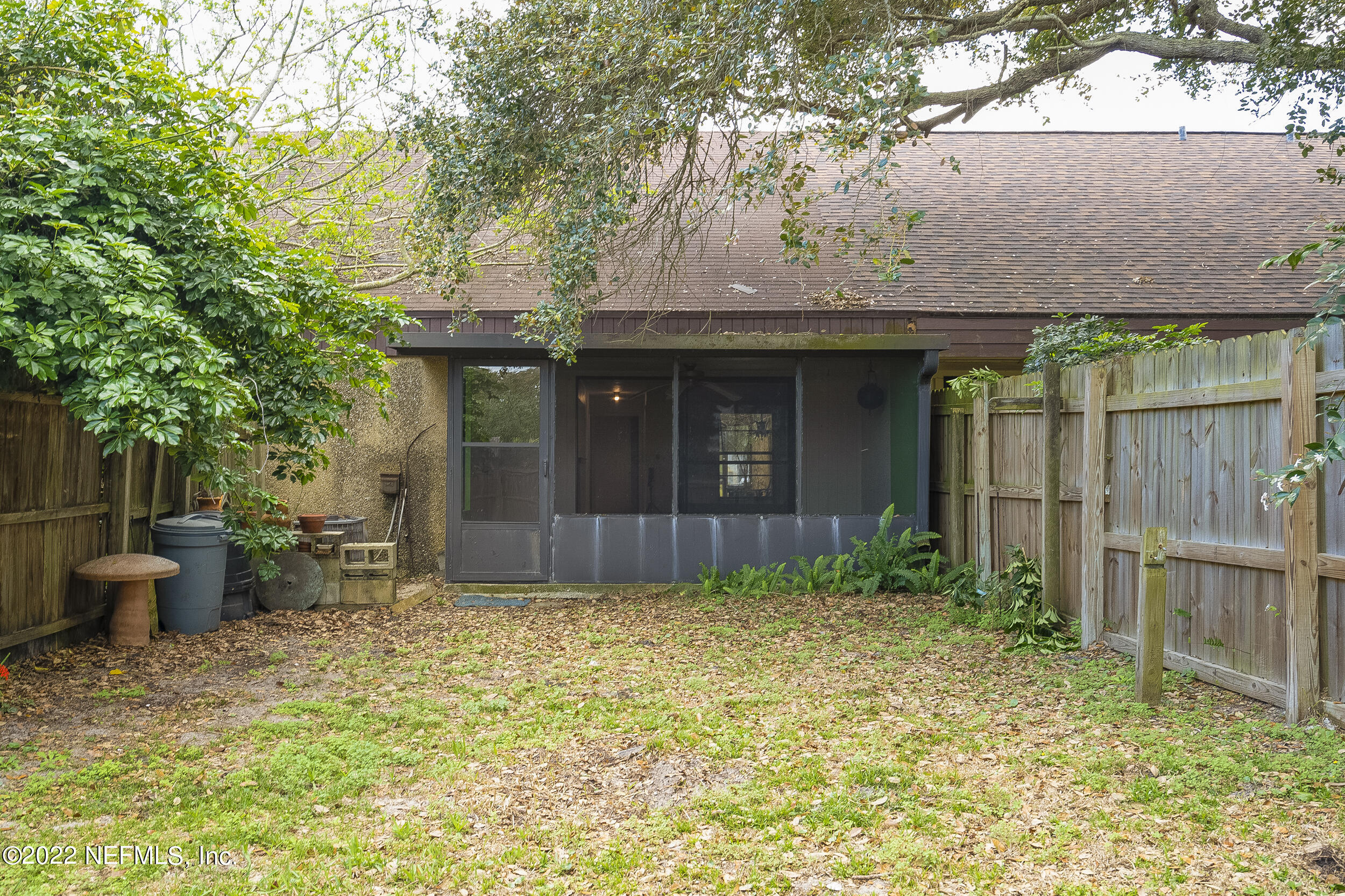 3403 Sanddollar Court St. Augustine, FL 32084 - Photo 27 of 47 a view of a backyard with potted plants and a large tree