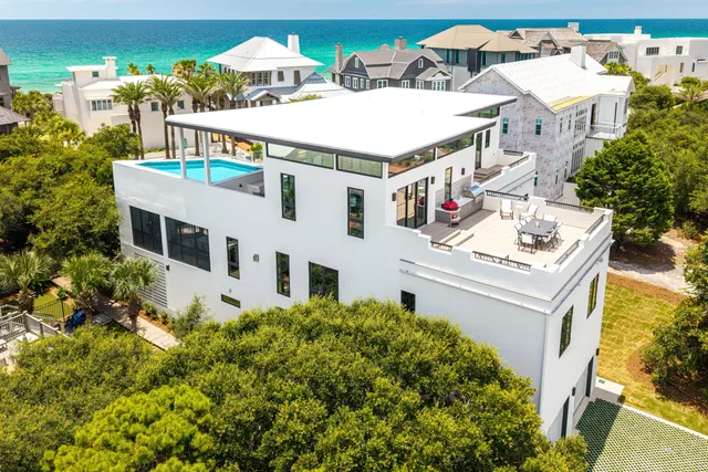 a white kitchen with a dining table chairs and a sink