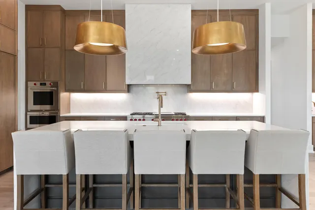 a living room with couches a flat screen tv and kitchen view