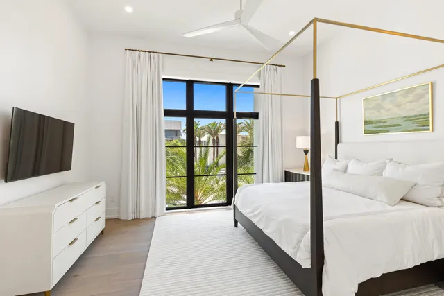 a view of a dining room with furniture a chandelier and large windows