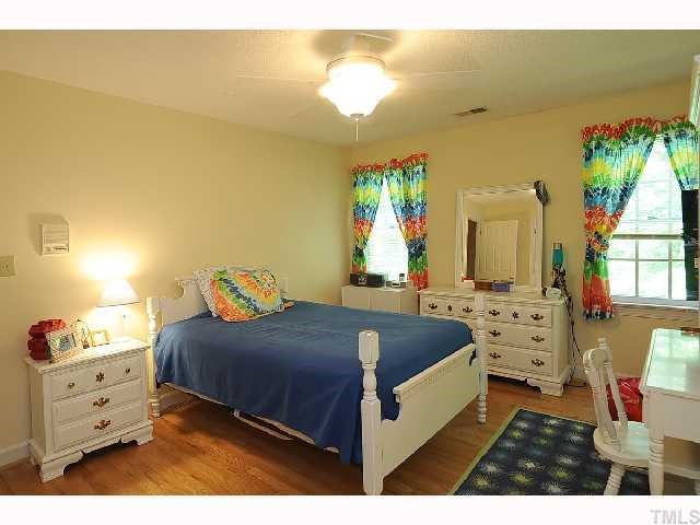 7705 Lambroll Lane Raleigh, NC 27613 - Photo 8 of 12 a spacious bedroom with a bed and a window