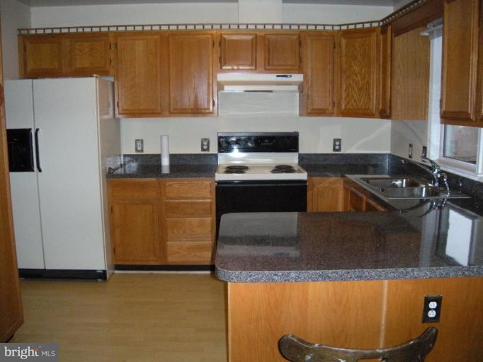4297 Bark Hill Road Union Bridge, MD 21791 - Photo 2 of 16 a kitchen with granite countertop a sink a stove and a refrigerator