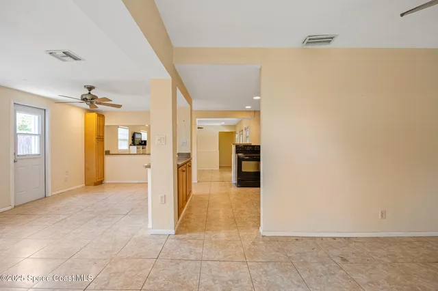 a view of a hallway with wooden floor and a living room