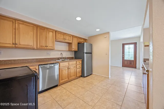 a kitchen with stainless steel appliances granite countertop a stove a sink and a refrigerator