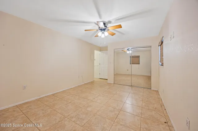 an empty room with windows and fan