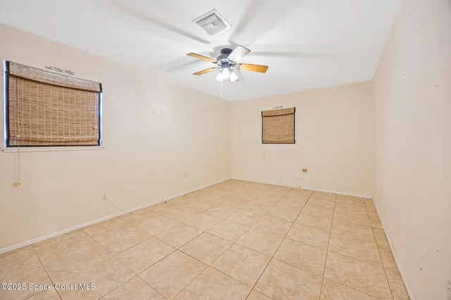an empty room with a window and a fan
