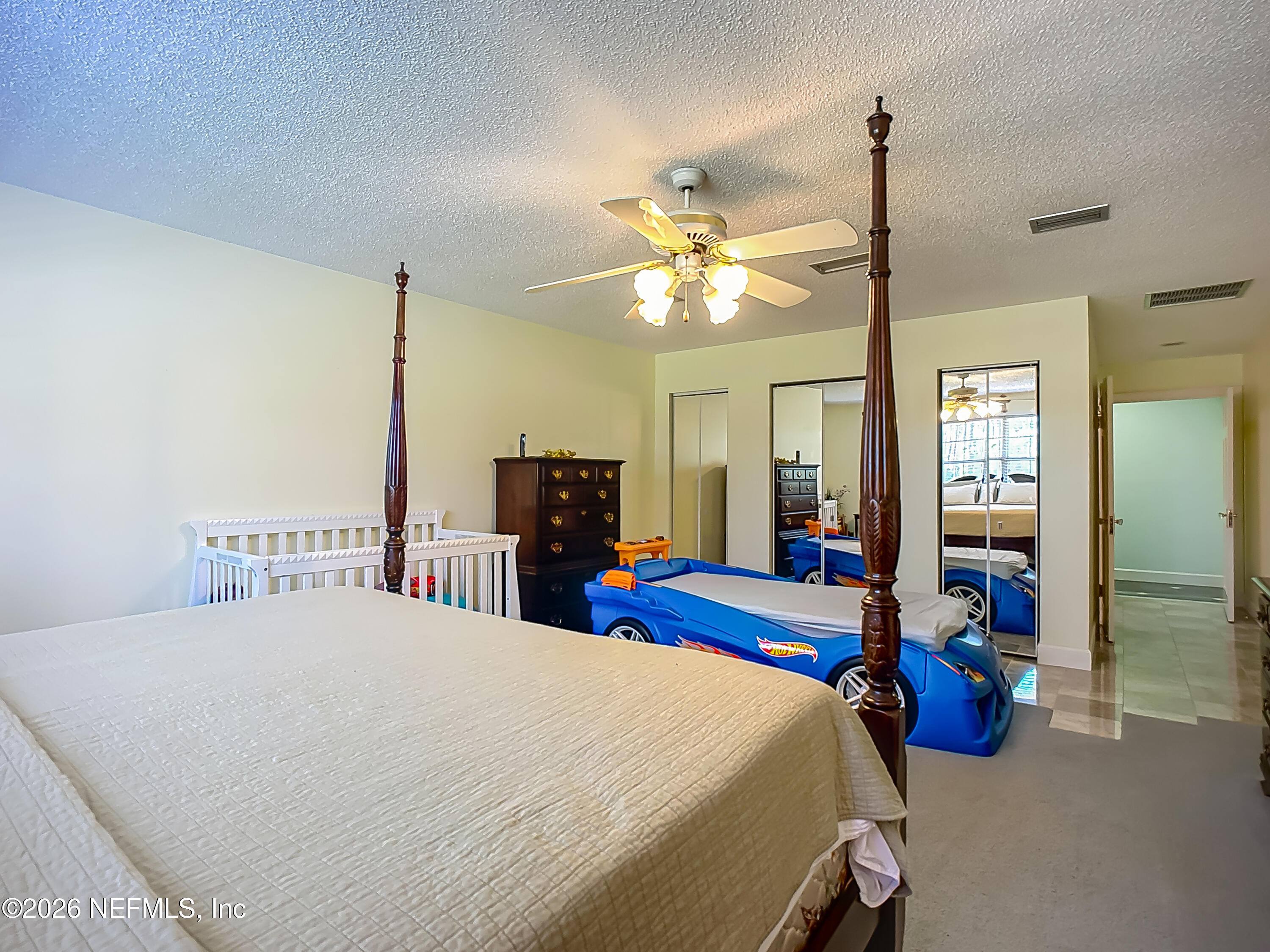 26504 Sheared Stokes Road Hilliard, FL 32046 - Photo 15 of 62 a bedroom with a bed and a chandelier