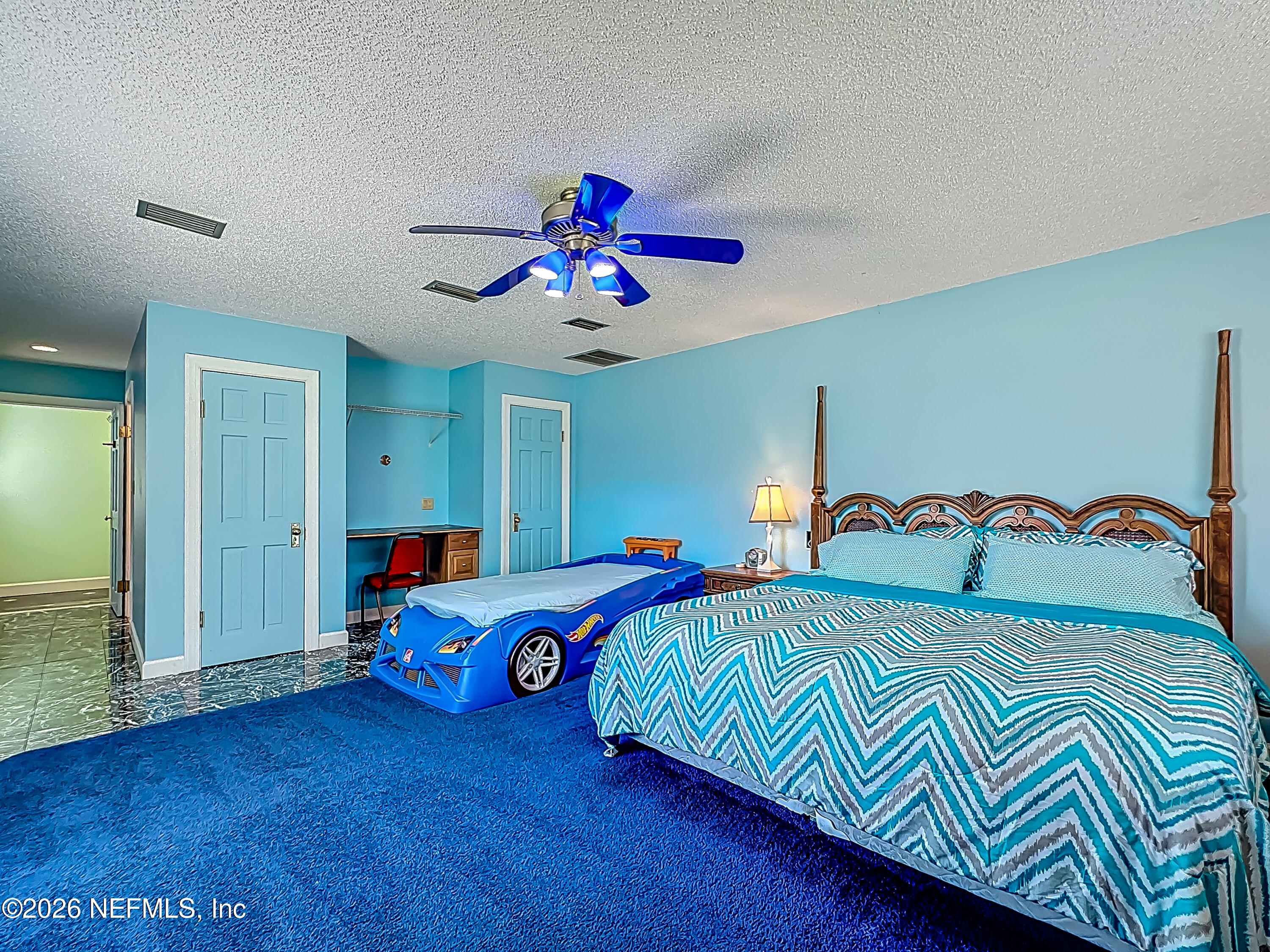 26504 Sheared Stokes Road Hilliard, FL 32046 - Photo 17 of 62 a bedroom with a bed and a chandelier