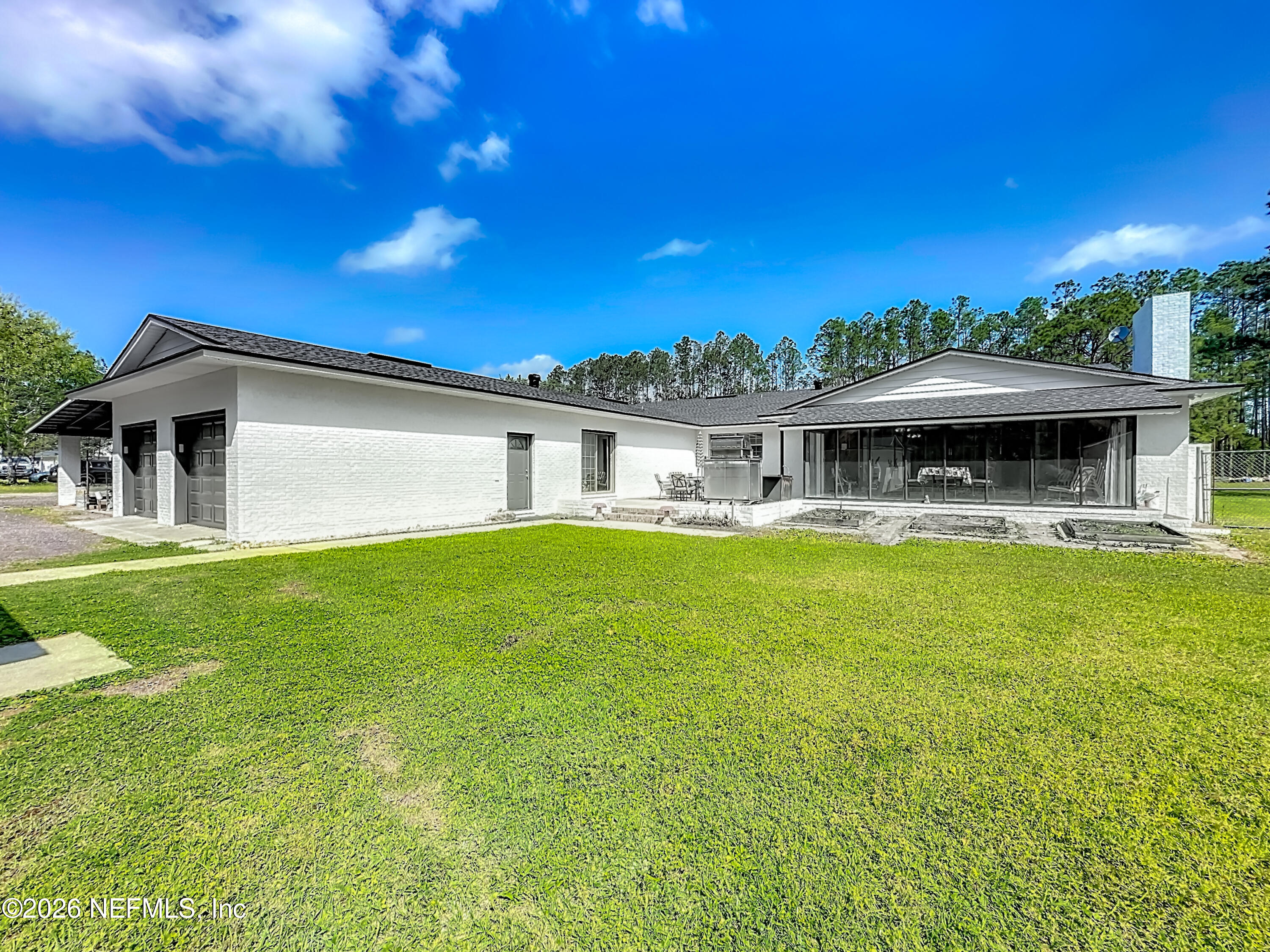 26504 Sheared Stokes Road Hilliard, FL 32046 - Photo 56 of 62 a front view of a house with yard swimming pool and outdoor seating