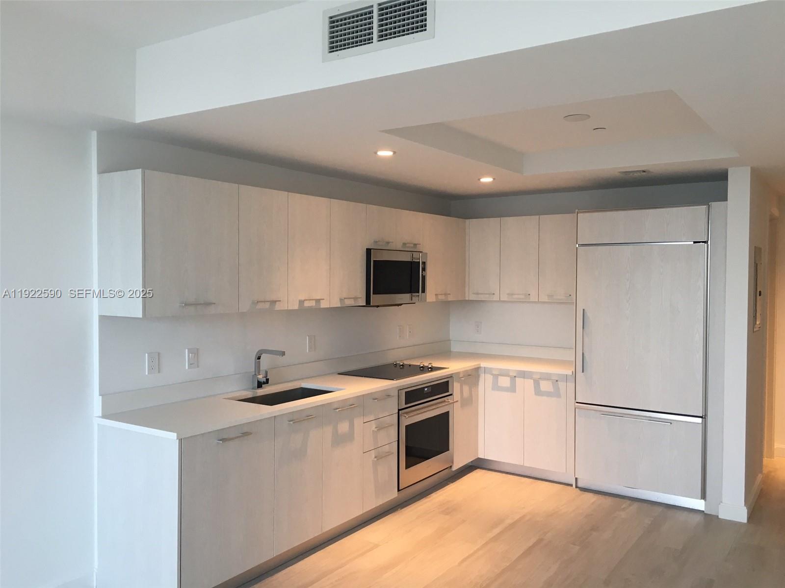 55 Southwest 9th Street, Unit 4005 Miami, FL 33130 - Photo 4 of 9 a kitchen with a sink a white cabinets and stainless steel appliances