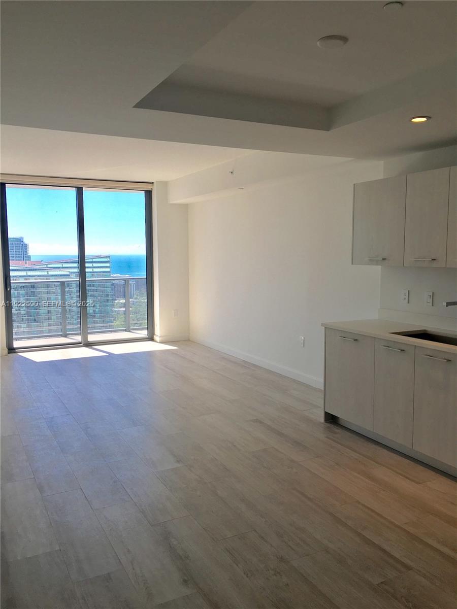 55 Southwest 9th Street, Unit 4005 Miami, FL 33130 - Photo 5 of 9 an empty room with wooden floor and windows