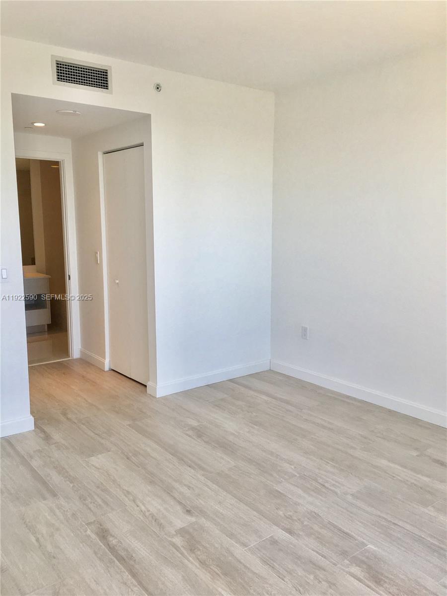 55 Southwest 9th Street, Unit 4005 Miami, FL 33130 - Photo 6 of 9 a view of an empty room with wooden floor