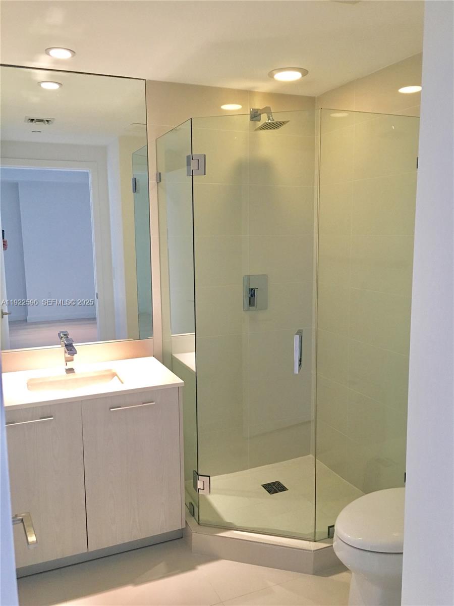 55 Southwest 9th Street, Unit 4005 Miami, FL 33130 - Photo 9 of 9 a bathroom with a bathtub shower sink vanity and toilet