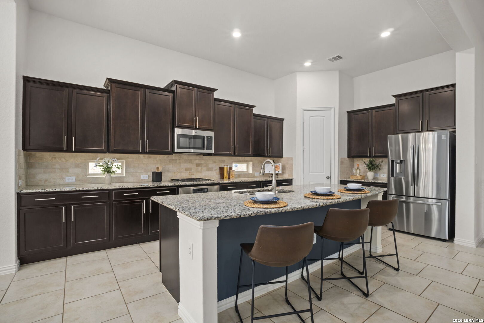 32134 Mirasol Bend Bulverde, TX 78163 - Photo 13 of 44 a kitchen with stainless steel appliances granite countertop a refrigerator a stove a sink and a microwave