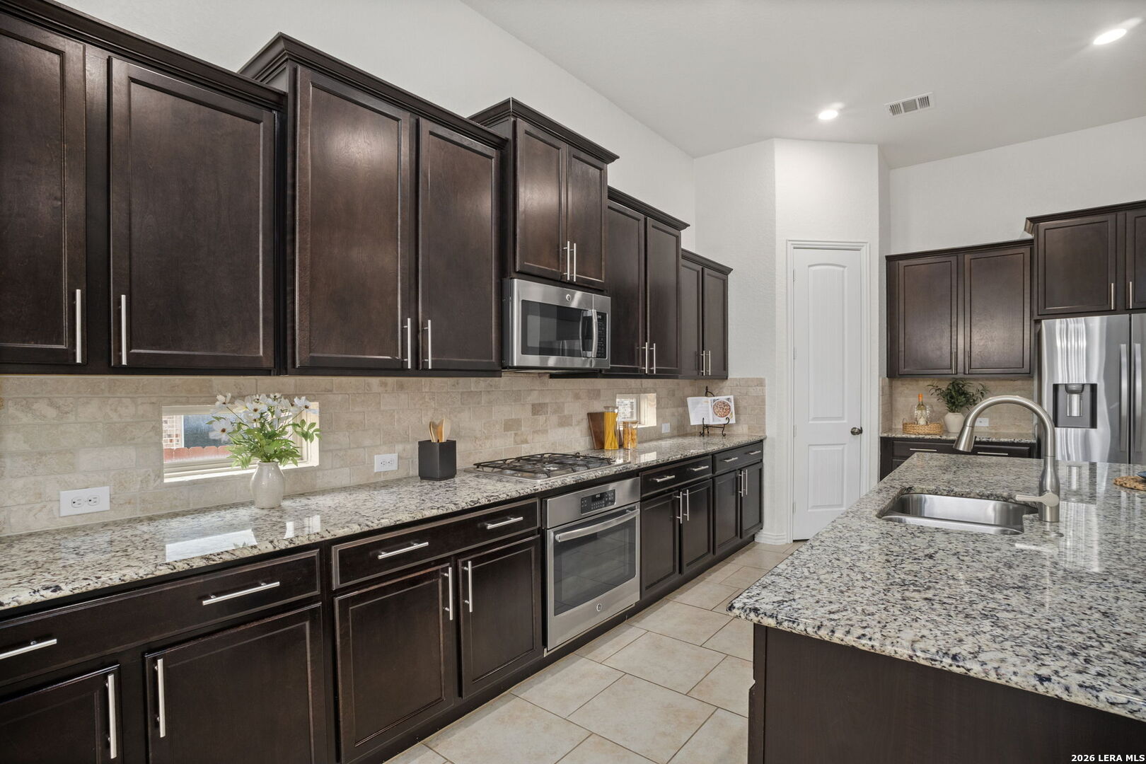 32134 Mirasol Bend Bulverde, TX 78163 - Photo 15 of 44 a kitchen with stainless steel appliances wooden cabinets a sink and a stove