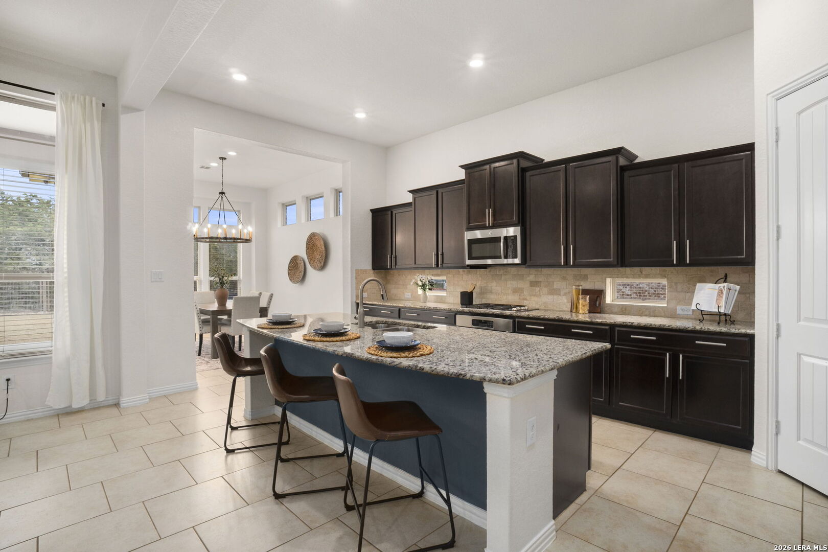 32134 Mirasol Bend Bulverde, TX 78163 - Photo 16 of 44 a kitchen with a stove a sink a dining table and chairs