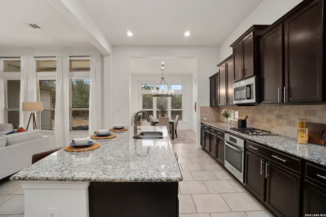 a kitchen with granite countertop a sink and a stove