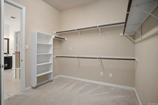 a view of an empty room with a window and a ceiling fan