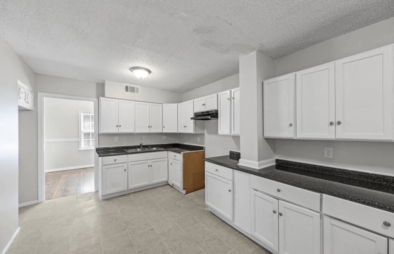 3843 Blue Jay Road Memphis, TN 38116 - Photo 12 of 23 a kitchen with granite countertop white cabinets and stainless steel appliances
