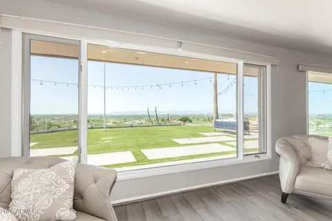 a living room with a large window and a bed