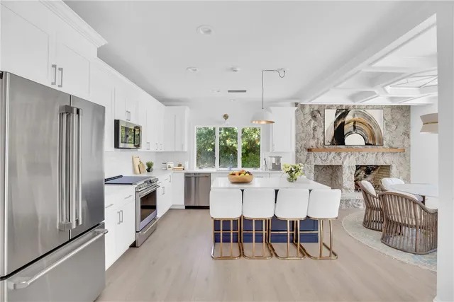 a large white kitchen with a table and chairs
