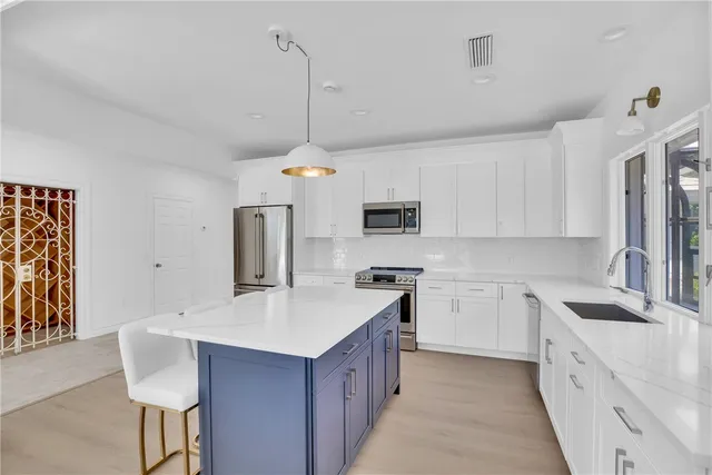 a kitchen with kitchen island a sink stove and refrigerator