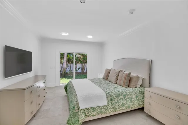 a bedroom with a large bed and a flat screen tv