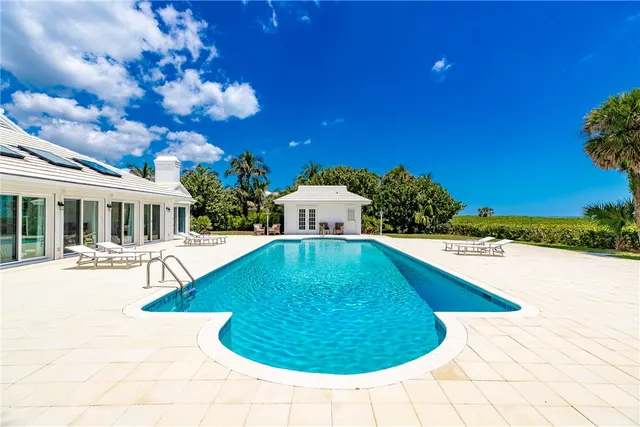a swimming pool with outdoor seating and yard