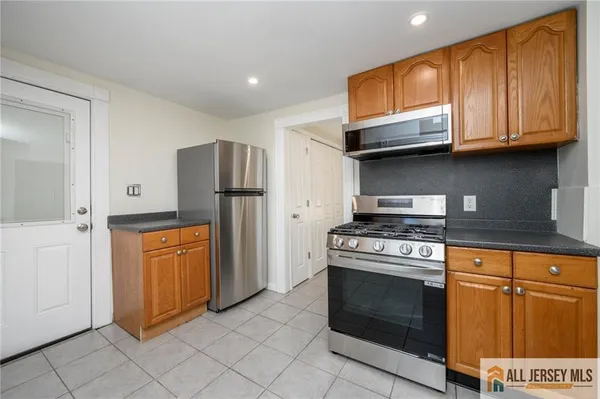 a kitchen with stainless steel appliances granite countertop a stove a refrigerator and a microwave
