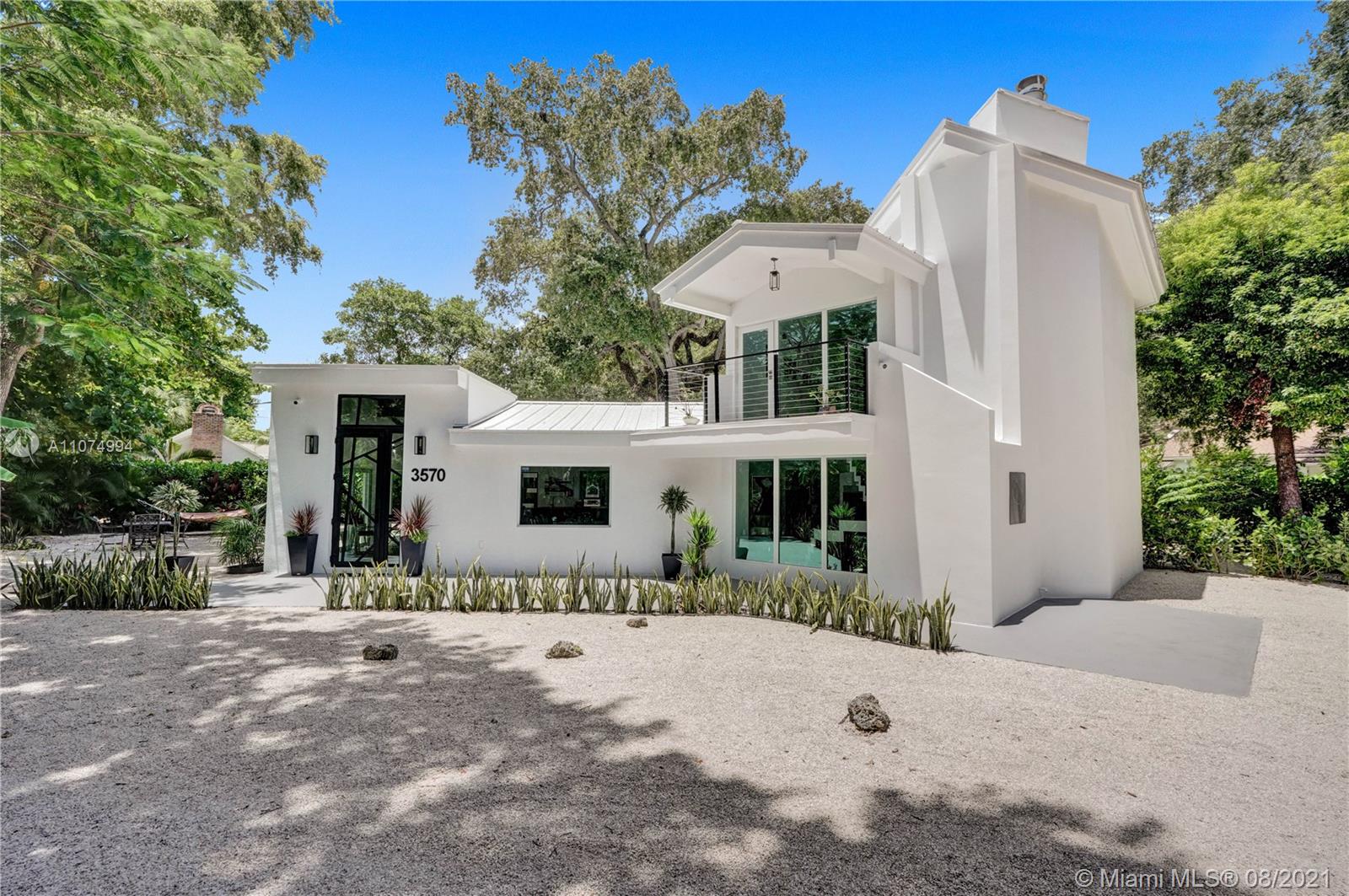 3570 Main Highway Miami, FL 33133 - Photo 2 of 76 a view of a white house with a yard and plants