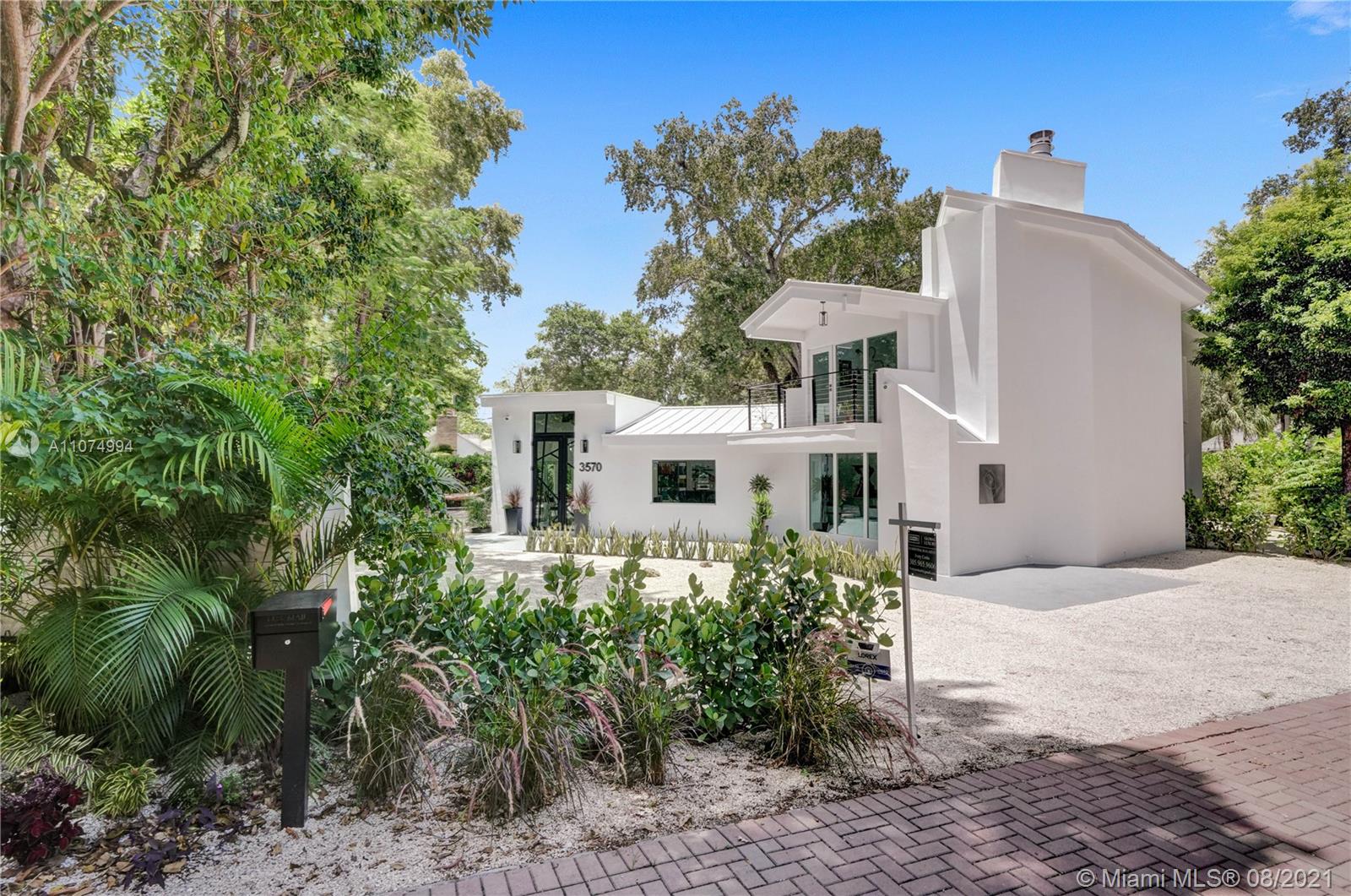 3570 Main Highway Miami, FL 33133 - Photo 3 of 76 a front view of a house with a yard and trees