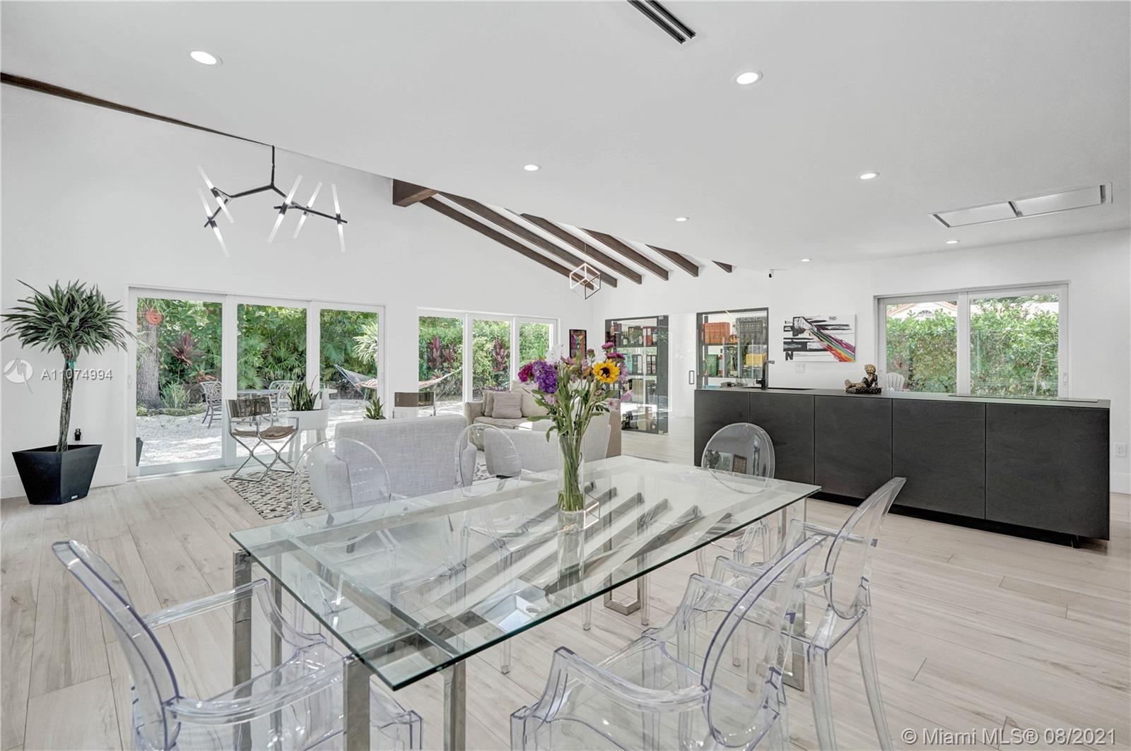 3570 Main Highway Miami, FL 33133 - Photo 21 of 76 a kitchen with stainless steel appliances kitchen island granite countertop a table and chairs in it