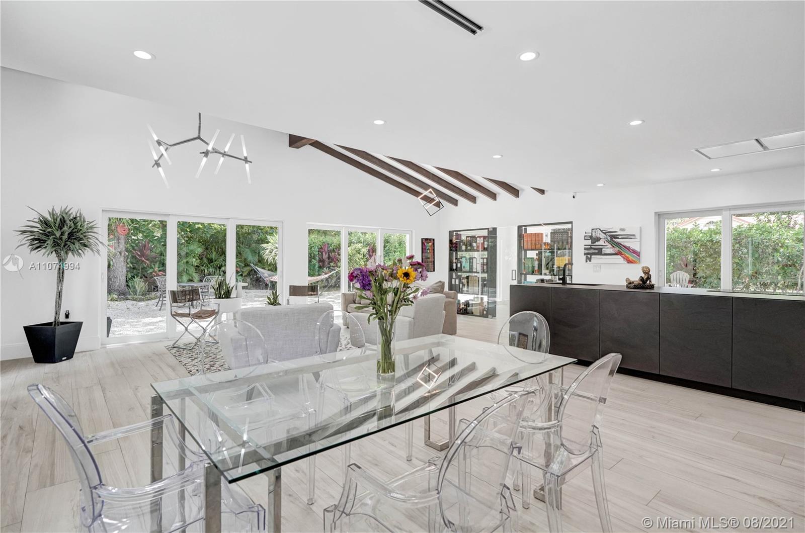 3570 Main Highway Miami, FL 33133 - Photo 25 of 76 a view of a dining room with furniture large windows and wooden floor