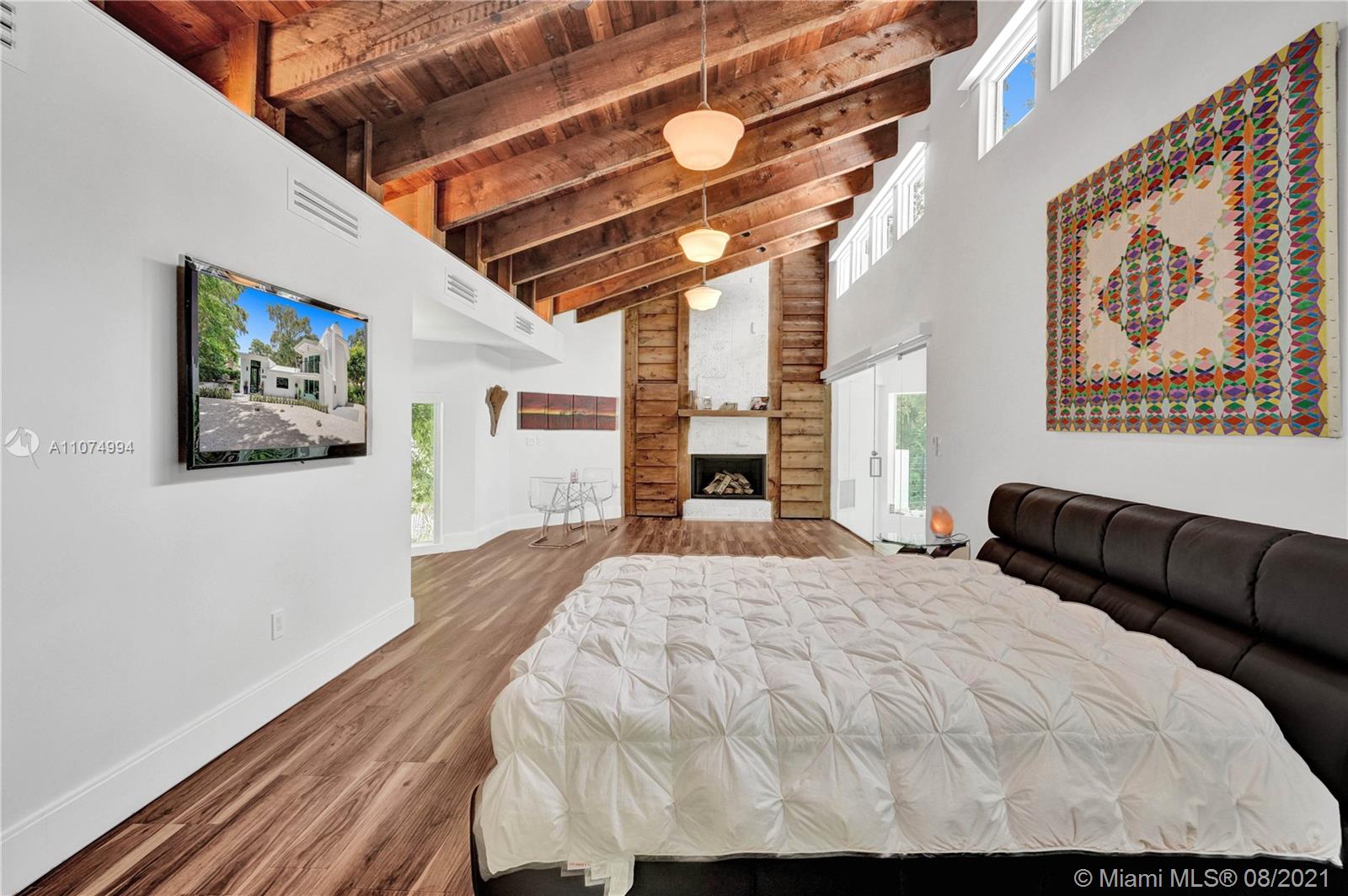 3570 Main Highway Miami, FL 33133 - Photo 32 of 76 a bedroom with a bed and a painting on the wall