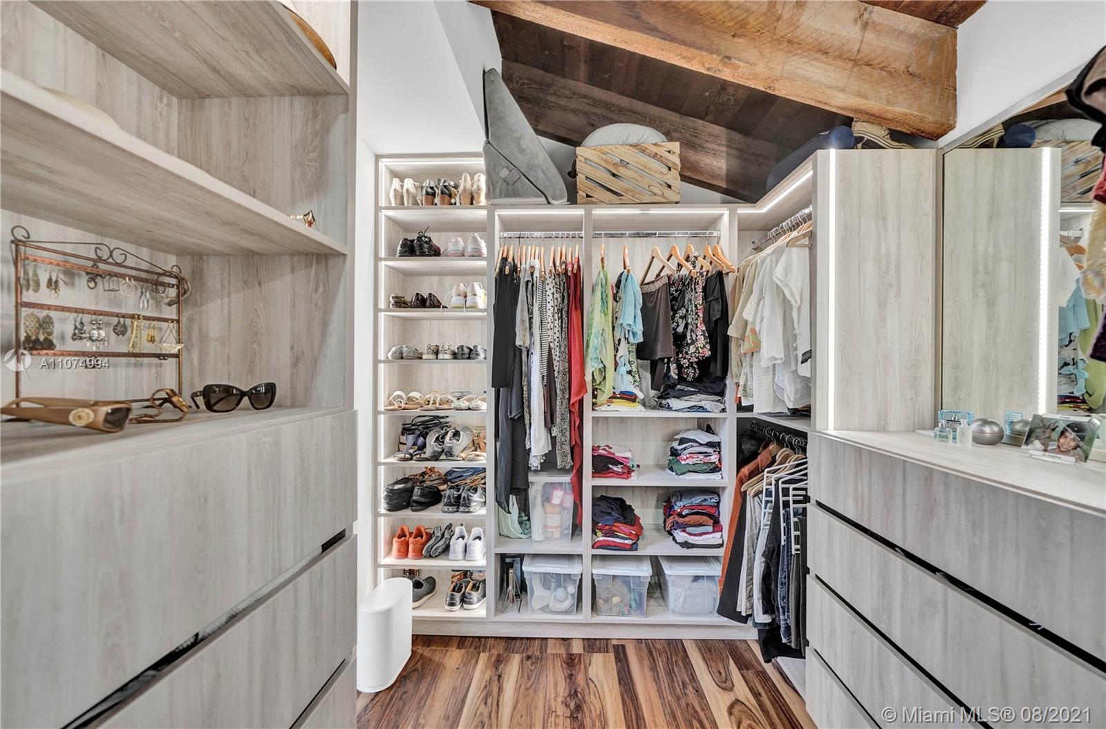 3570 Main Highway Miami, FL 33133 - Photo 34 of 76 a view of walk in closet with clothes and shoes