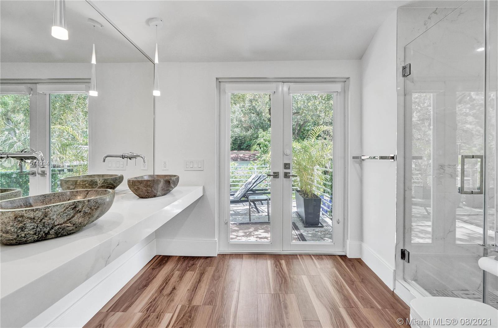 3570 Main Highway Miami, FL 33133 - Photo 36 of 76 a large white room with a large window and a couch